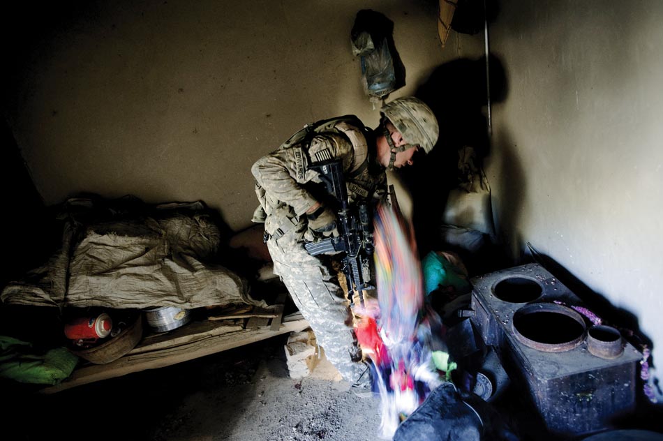 A soldier from Second Platoon Apache Company searches an abandoned qalat moments after an IED exploded on a nearby road.