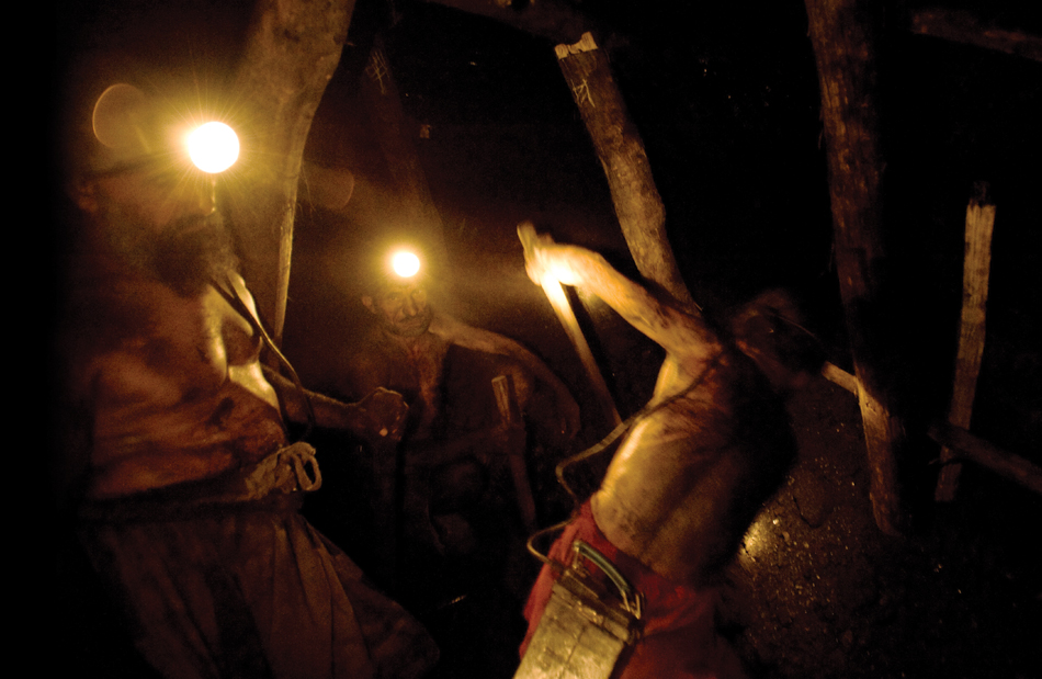 Workers shovel coal in the Karkara mine.