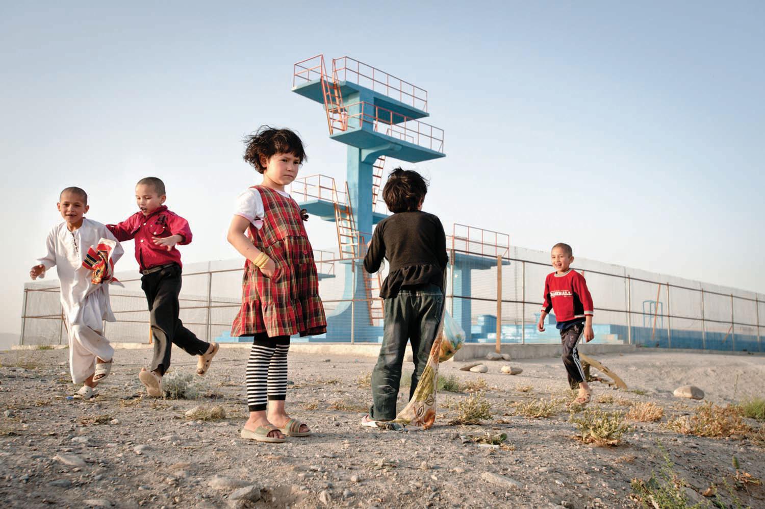 Children play atop Bibi Mahru Hill in central Kabul, next to an olympic swimming pool and platform diving boards constructed by the Soviets. Local lore has it that the Taliban used to force suspected homosexuals to jump from the highest platform; if they lived, they were deemed innocent, but if they died, it was trial, sentencing, and punishment in one fatal plunge.