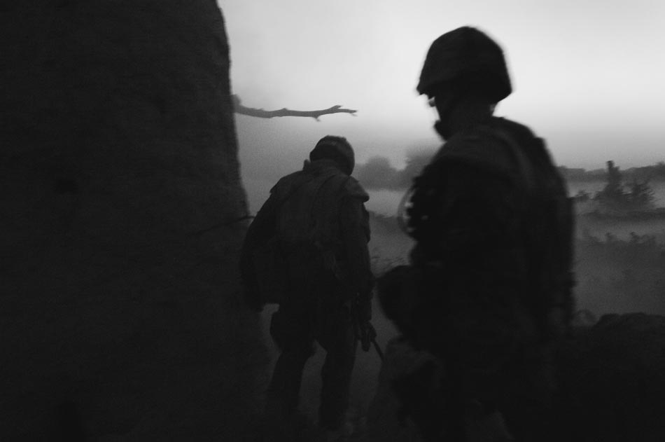 Canadian soldiers walk through smoke and dust at dusk after blasting an insurgent weapons cache in the Sperwan area of Panjwai District.