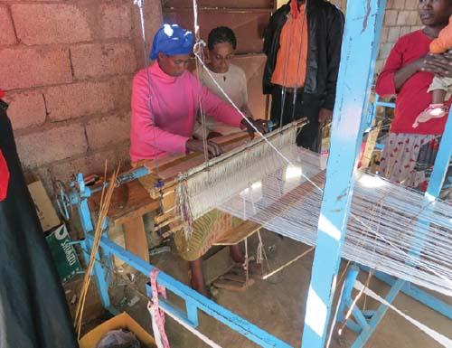 Zeritu Zerga (second from left) looks on as a weaver works at a co-op helping fuelwood carriers find new professions.
