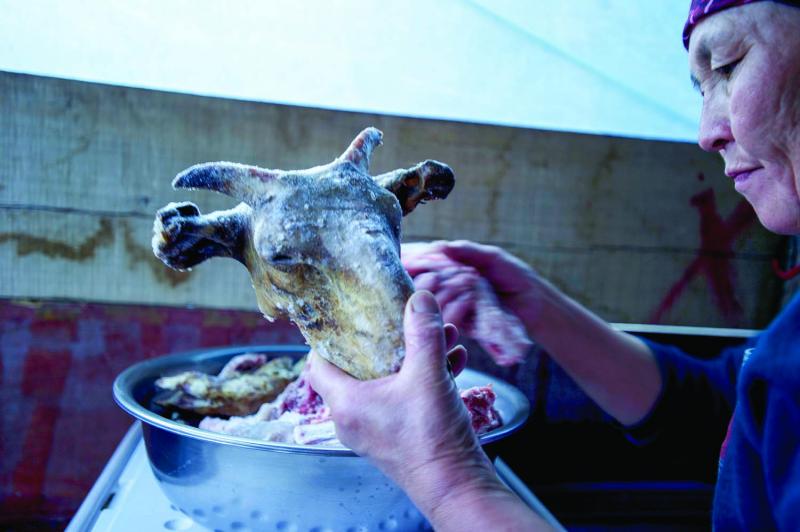 Mapura scrapes meat off the head of a goat cooked in the park. The cheeks are considered a delicacy.  