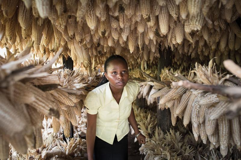 Lilian Uwintwali walks through drying maize at the Impabaruta cooperative. Uwintwali created a health-care app and is now developing an app to improve farming practices.