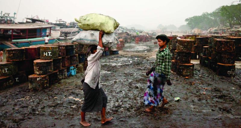 Women laborers off-load sacks of charcoal near the Mandalay jetty. Photo by Jason Motlagh.