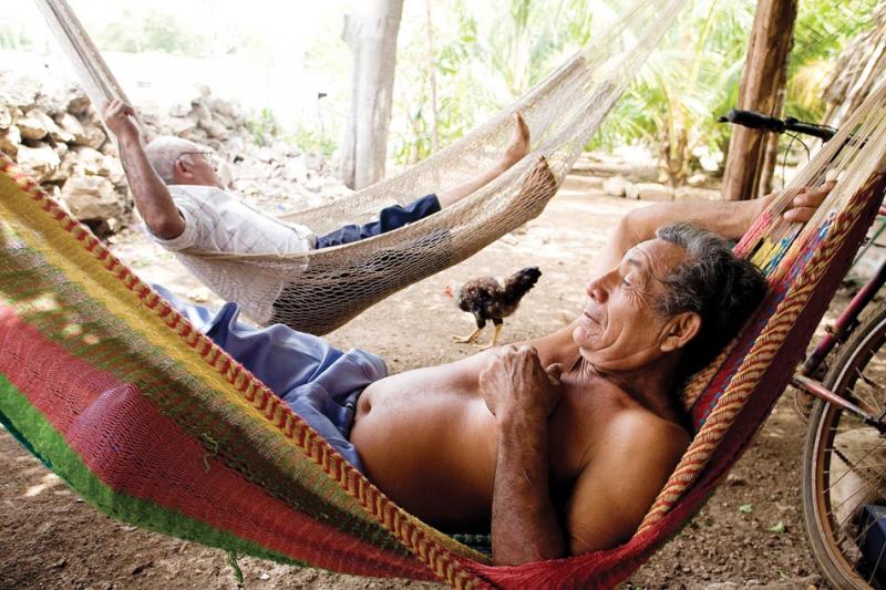 Eduardo and Celso relax in hammocks during the heat of midday.