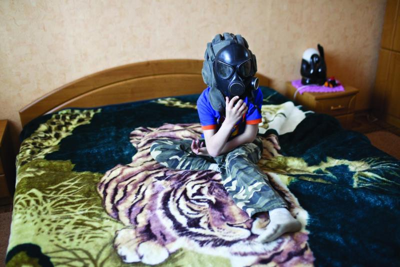 Artiom Mishko plays in his parent's bedroom with a gas mask that is now nothing more than a toy and a relic of a Soviet era that he does not remember.