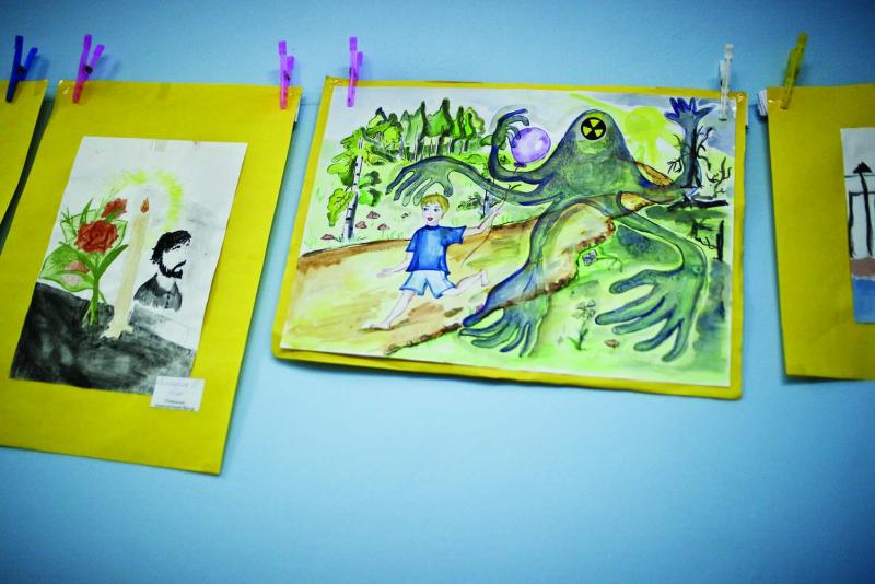 Children's drawings depicting radioactive contamination hang in the daycare activity room of the Social Service Center in Slavutych.