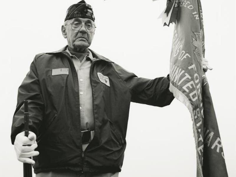 A World War II veteran holds a flag during a service at the Cavalry Cemetery in Eveleth, Minnesota, on Memorial Day, May 26, 2008. Noah Pierce, who is buried there, returned after two tours of Iraq with severe PTSD and committed suicide near his family home on July 26, 2007 (ASHLEY GILBERTSON).