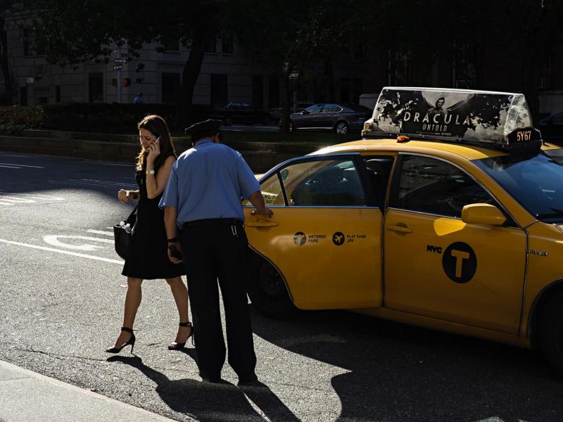 Woman exiting cab, Upper East Side, New York.